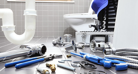 a number of plumbing parts and tools laid on a bathroom floor