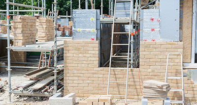 a house extension project underway with scaffolding and laid bricks