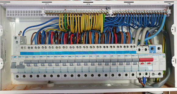a fuse box with organised wires inside after a rewiring