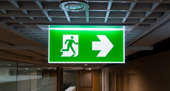 an emergency exit light illuminated in a dark hallway